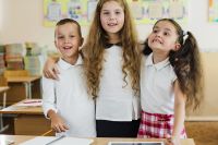 schoolchildren standing classroom hugging